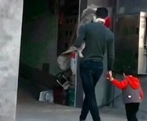 A man with a pet dog on his shoulder with his daughter in his hand. Warm. Heart