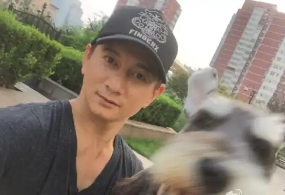 Wu Chilong takes a picture with a cage and learns how to play on the carpet with a dog