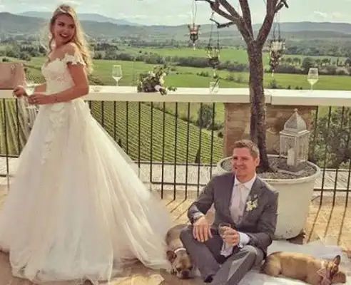 The dog sleeps on the wedding dress when it's taken pictures, and the man's action is on